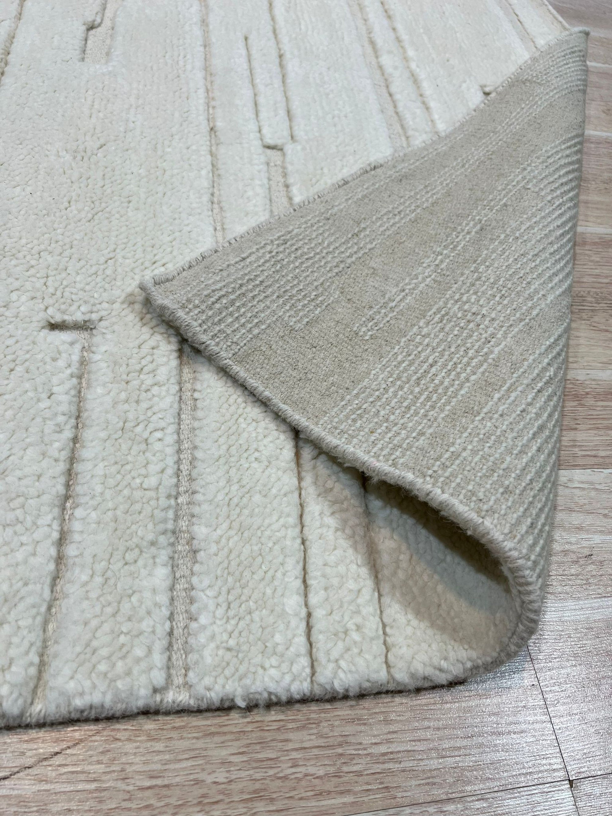 Para Vibrant White Hand Knotted Wool Rug, a creamy wool rug hand-knotted with a subtle, textural design, nestled within a bright and airy living space.