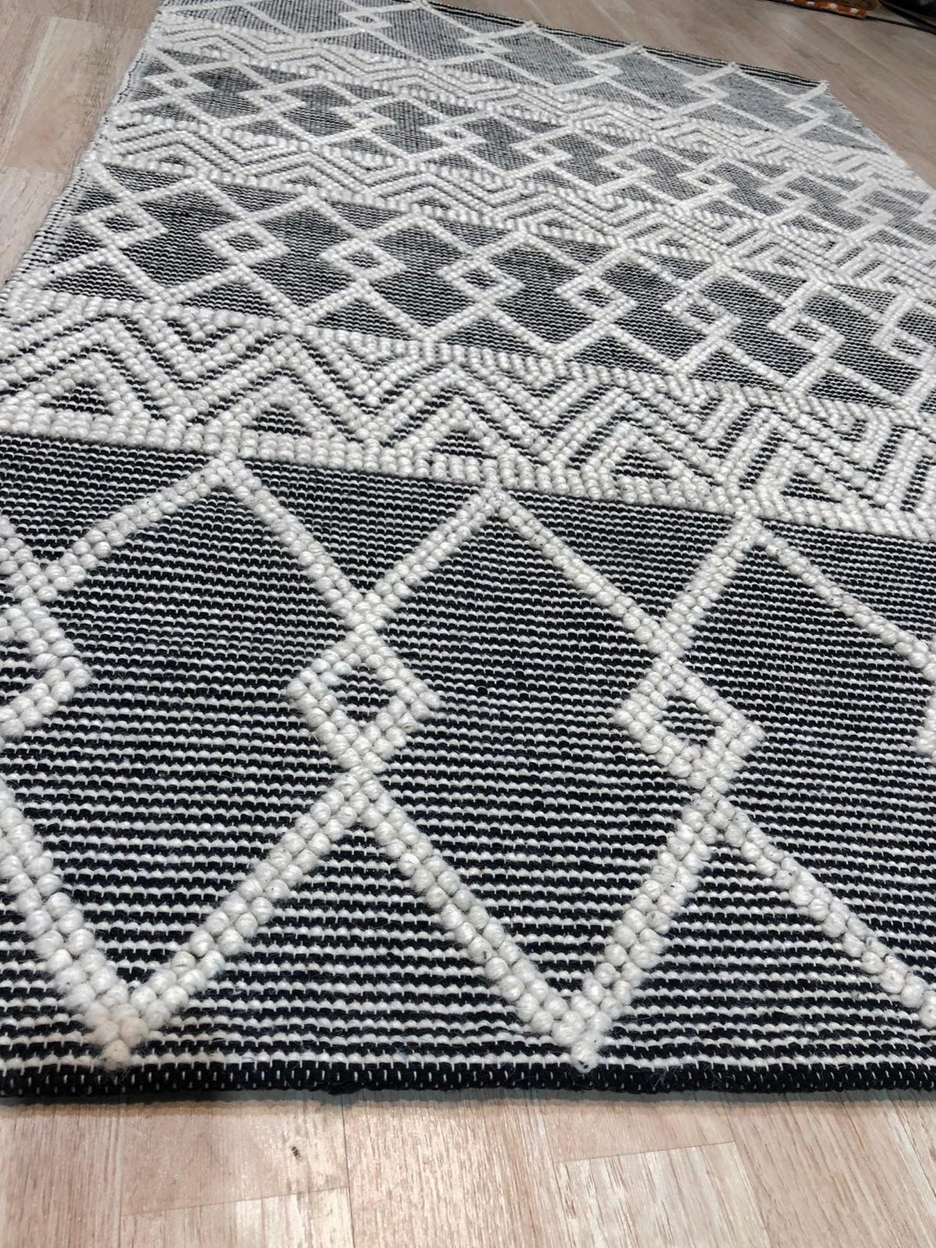 Modern Kilim Black Handmade Wool Rug, richly textured in deep black wool, anchoring a contemporary living room with its geometric kilim design.