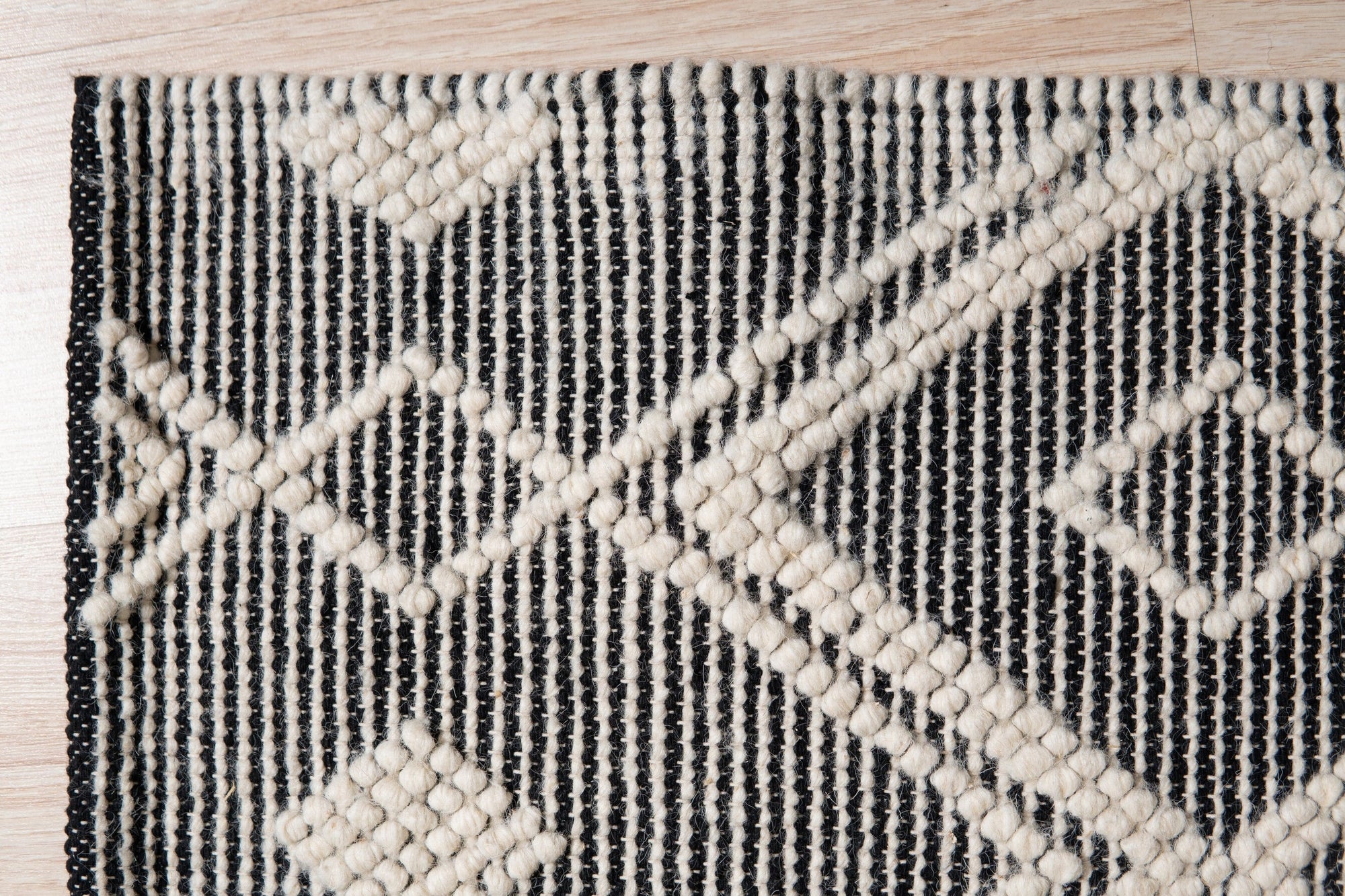 Modern Kilim Black Handmade Wool Rug anchors a light-filled living space, its textured black wool grounding a modern aesthetic with geometric patterns and subtle, hand-crafted variations.