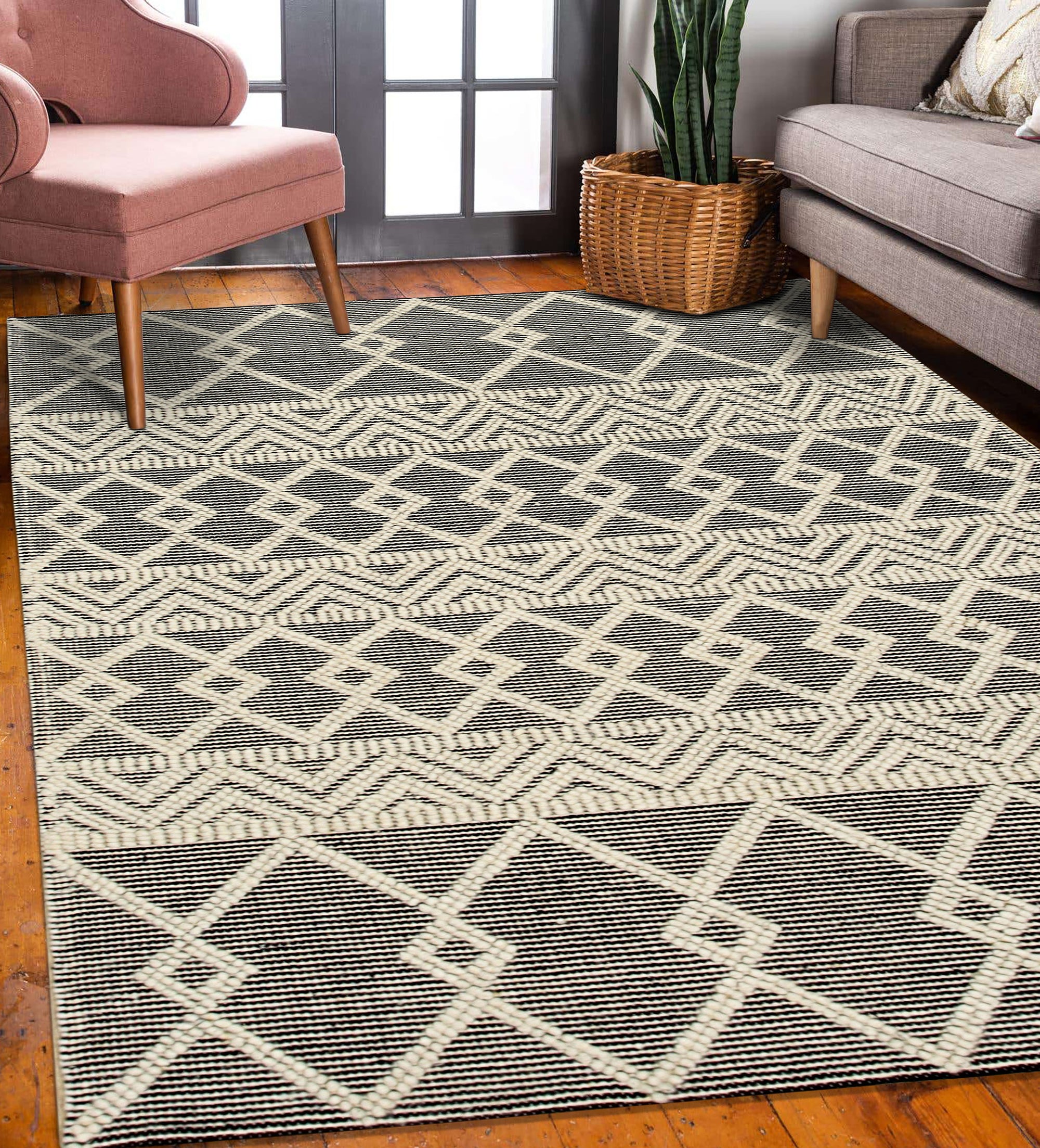 Modern Kilim Black Handmade Wool Rug displayed in a bright living room, its geometric pattern grounding a space with white walls and mid-century modern furniture.