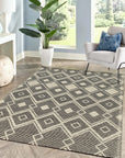 Luna Kilim Black Handmade Wool Rug, showcasing its handwoven texture and bold geometric pattern in a modern living space with light wood floors and neutral furniture.