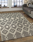 Luna Kilim Black Handmade Wool Rug, featuring intricate geometric patterns in shades of black and white, laid on a light wooden floor creating a striking contrast.