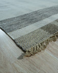 Giselle Serene Multicolor Flatweave Wool Rug displayed in a bright living space. The rug's flatweave construction showcases a serene blend of multiple colors, grounding the light-filled room.
