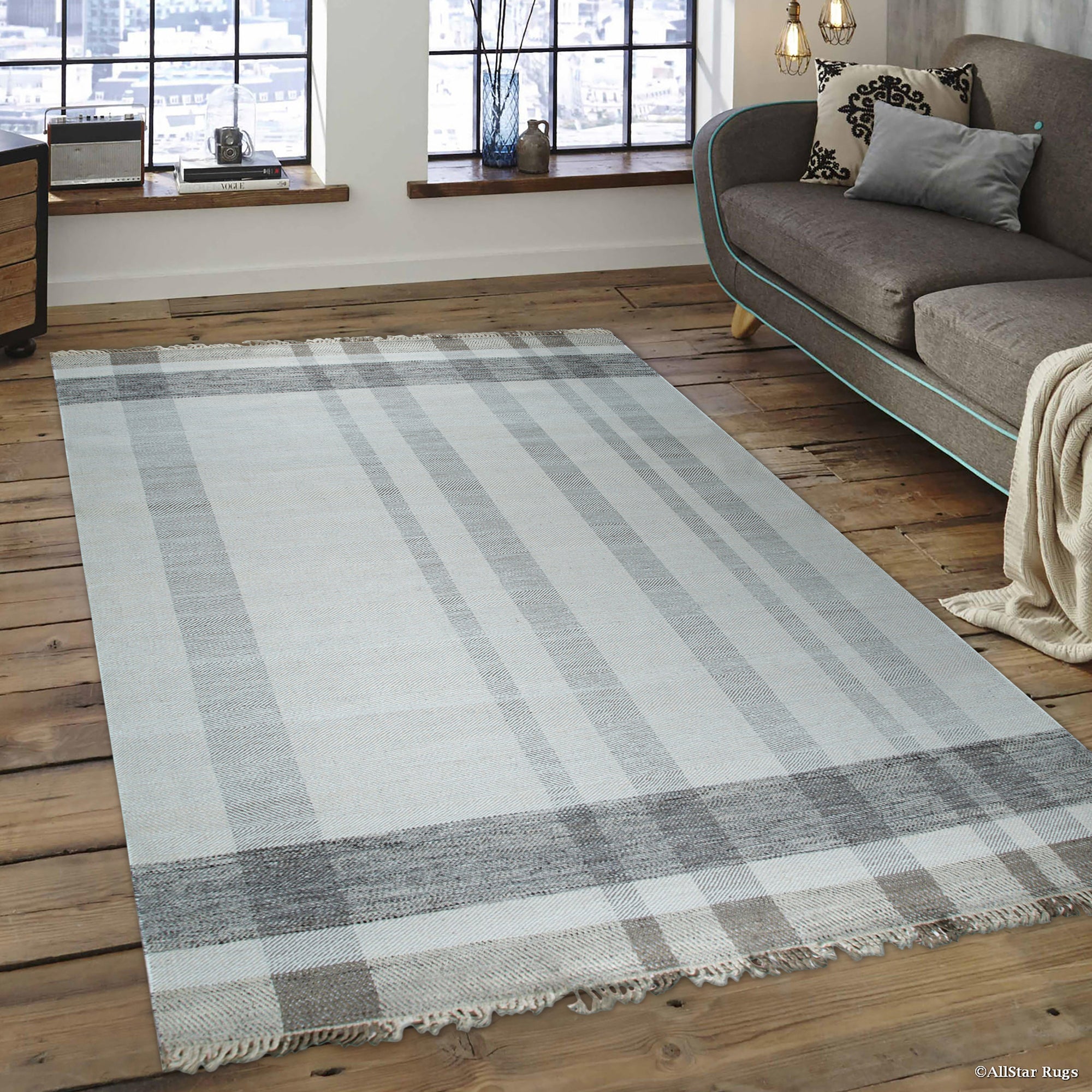 Giselle Serene Multicolor Flatweave Wool Rug displayed in a bright, modern living room. The rug's flatweave construction allows for visible texture and intricate geometric patterns woven with serene shades.