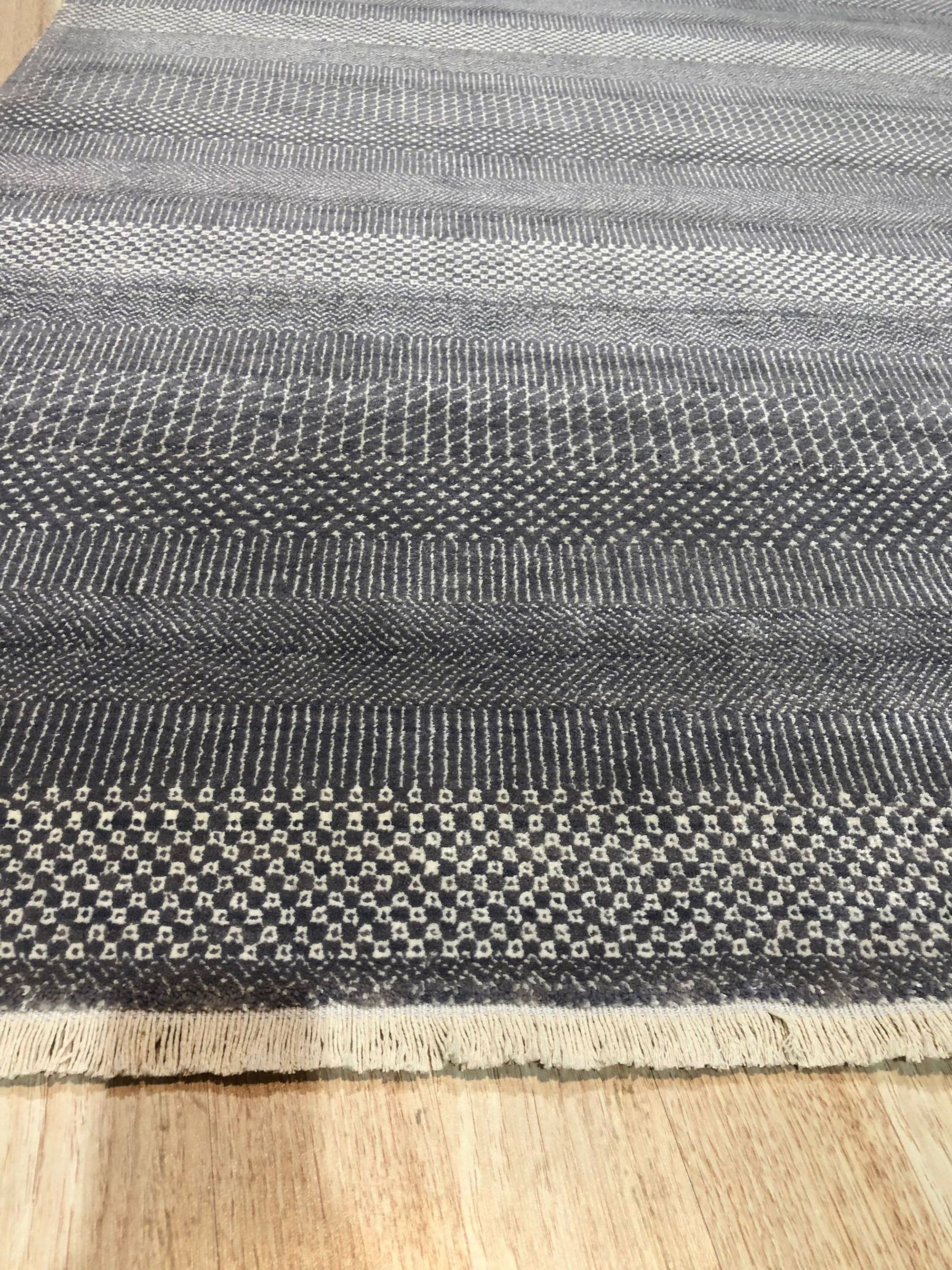 Dazzling Chic Gray Hand Knotted Wool & Viscose Rug, a blend of cool gray tones and lustrous sheen, laying elegantly in a modern living space.