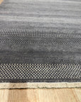 Dazzling Chic Gray Hand Knotted Wool & Viscose Rug, a blend of cool gray tones and lustrous sheen, laying elegantly in a modern living space.