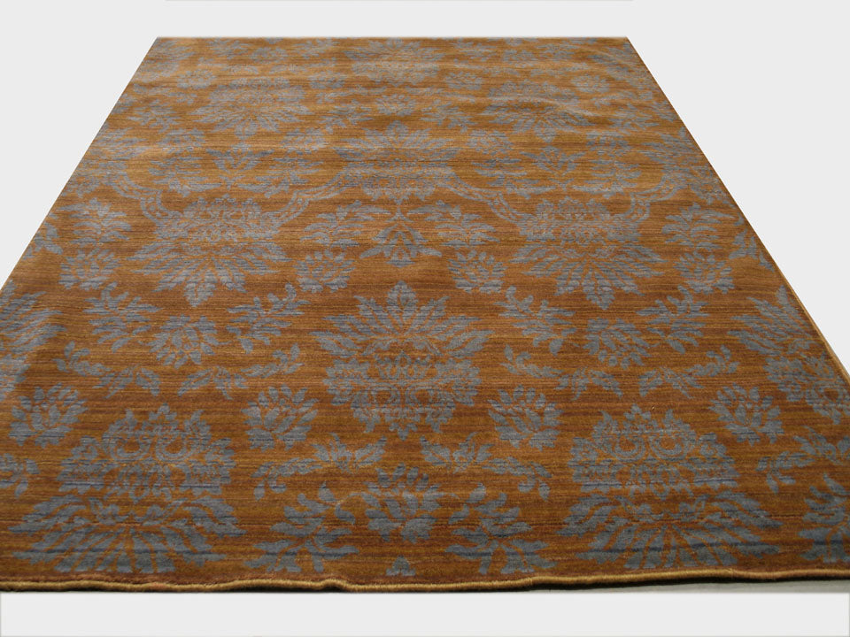 Ruby Inviting Brown Machine Made Wool Rug, a warm, inviting brown wool rug with a subtle, textured design, partially visible in a well-lit room setting.