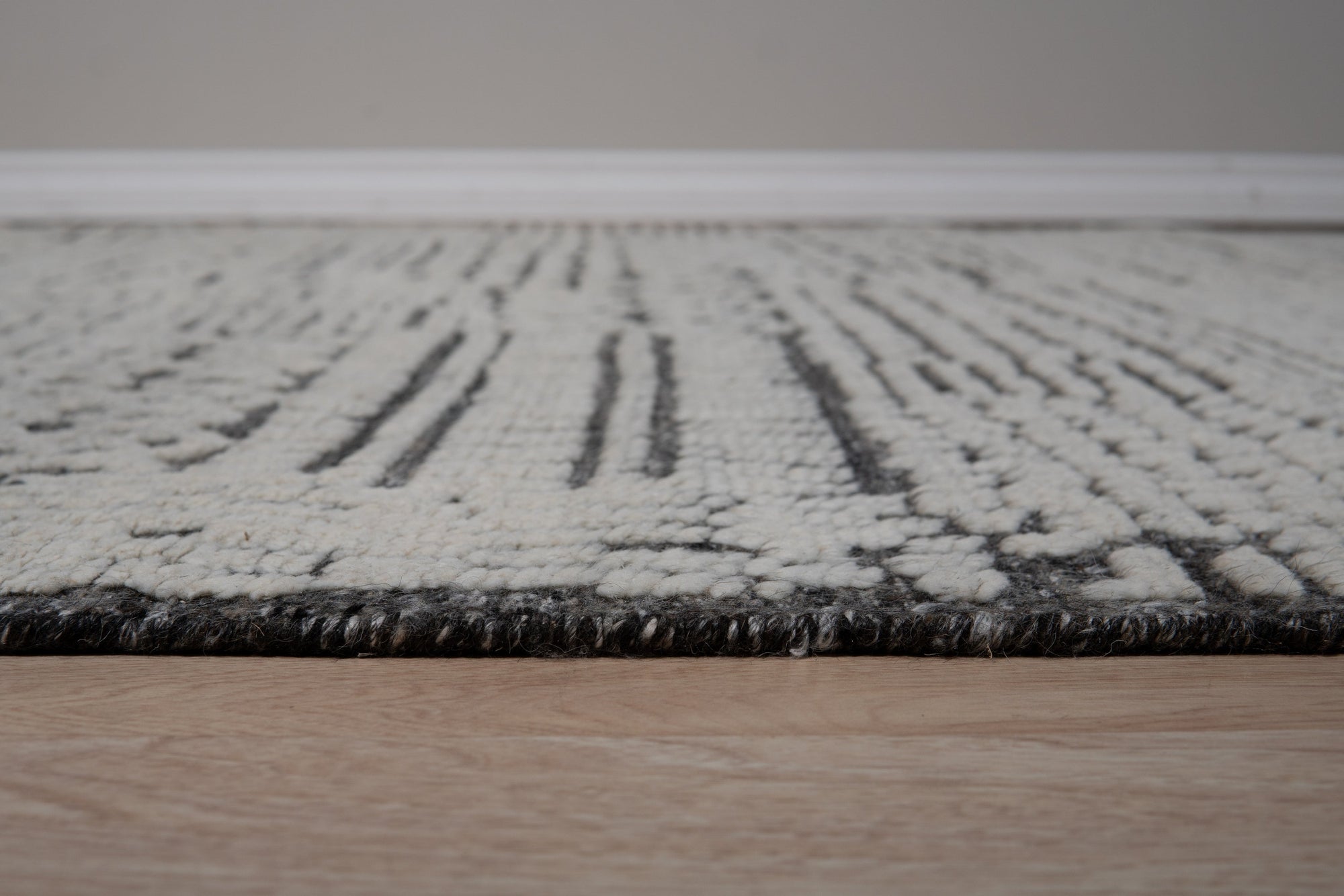 Sloane Sophisticated Ivory Hand Knotted Wool Rug, subtly patterned ivory wool field provides understated elegance within a softly lit interior.