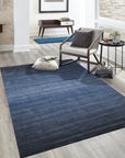 Louie Dazzling Blue Hand Tufted Wool Rug, displaying rich blues and subtle variations in texture, laid on a light hardwood floor, inviting warmth and sophisticated style into the living space.