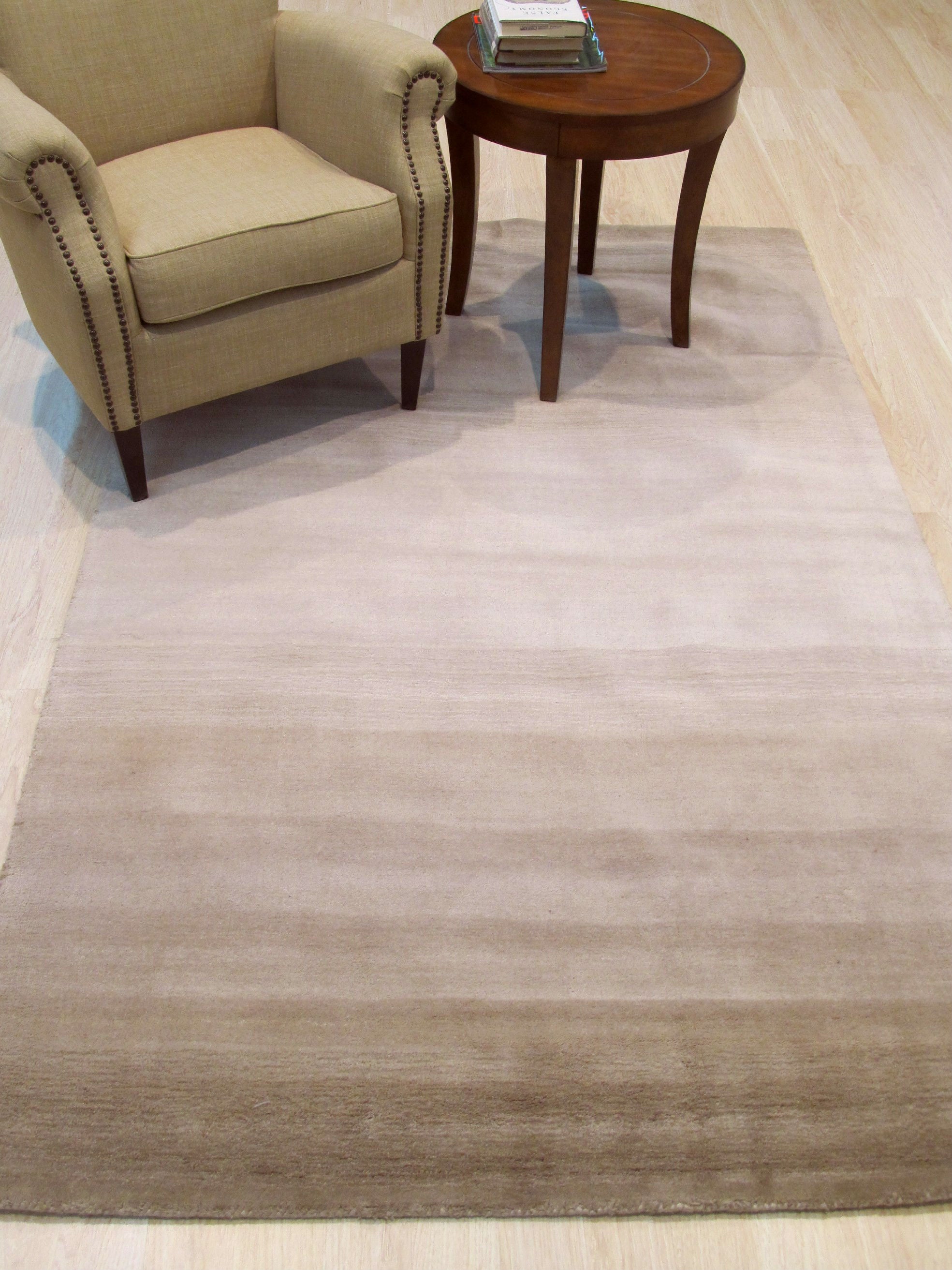 Vibrant Kira Beige Handmade Wool Rug, a warm beige wool rug with a subtly patterned design, complements a modern living space with light wood flooring and neutral furniture.