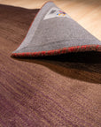 Rhea Unique Multicolor Handmade Wool Rug, showcasing vibrant shades of blue, orange, red, and yellow woven in a geometric pattern.