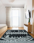 Marrakech Essence Black Rug displayed in a bright, minimalist living room; its intricate geometric pattern in contrasting shades adds a touch of bohemian chic to the modern space.