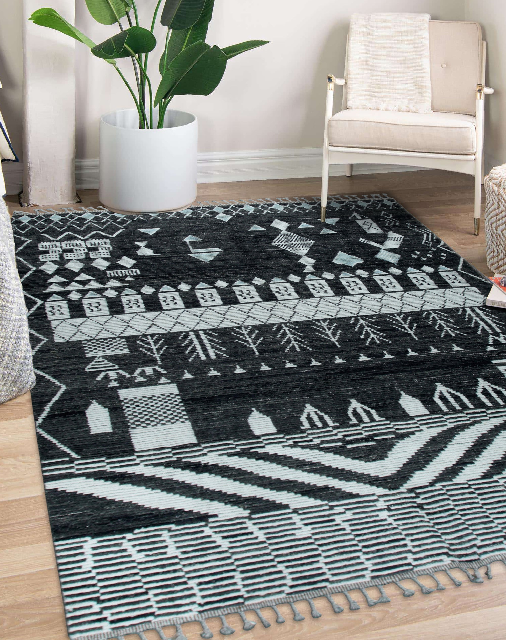 Marrakech Essence Black Rug in a bright living space; black geometric patterns dance across a light-colored rug, softening a modern room with a plush feel.