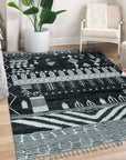 Marrakech Essence Black Rug in a bright living space; black geometric patterns dance across a light-colored rug, softening a modern room with a plush feel.