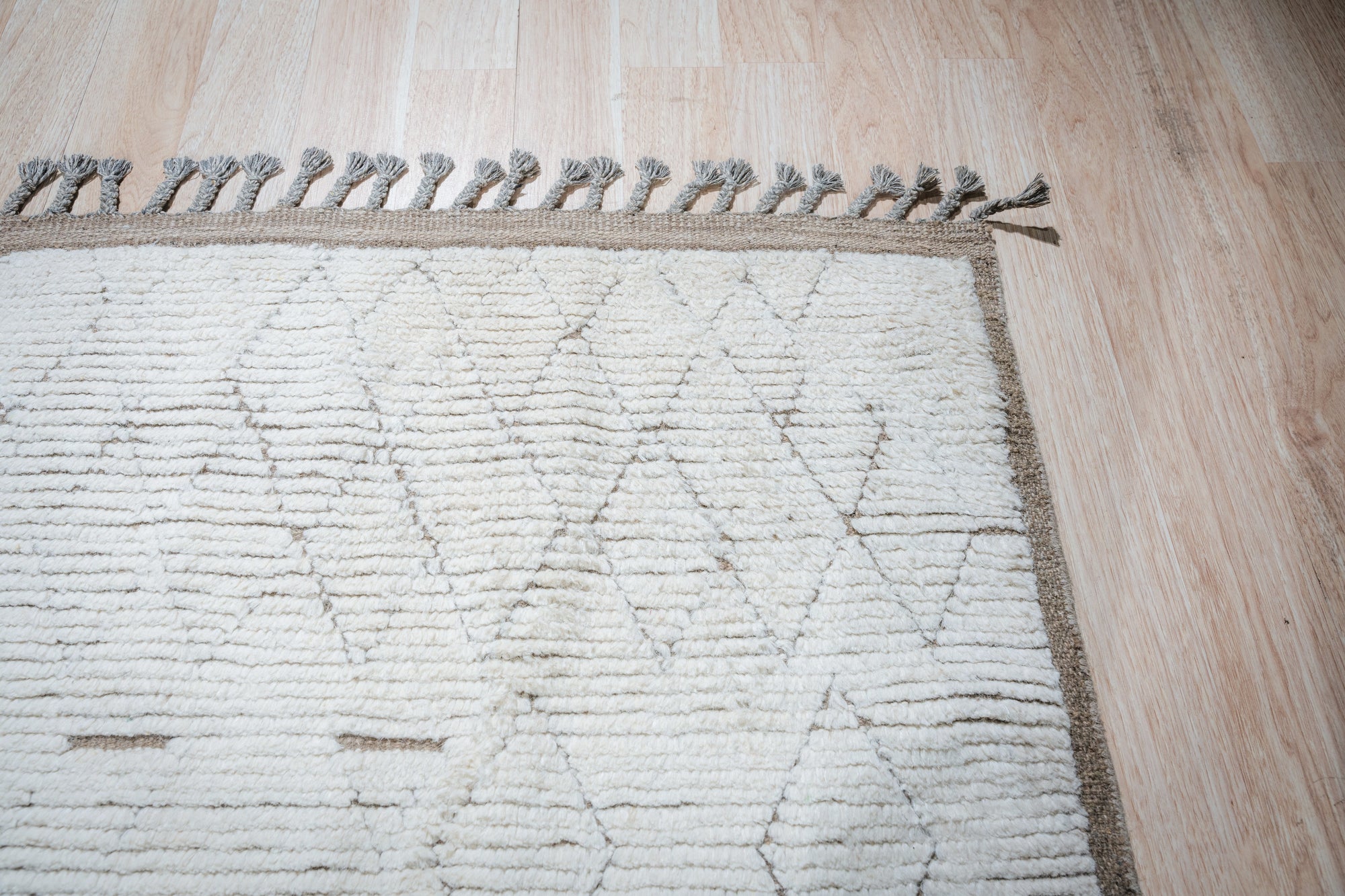 Marrakech Serenity Ivory Rug, its soft ivory tones and subtle geometric patterns complement a light-filled living room, showcasing a cozy and inviting atmosphere.