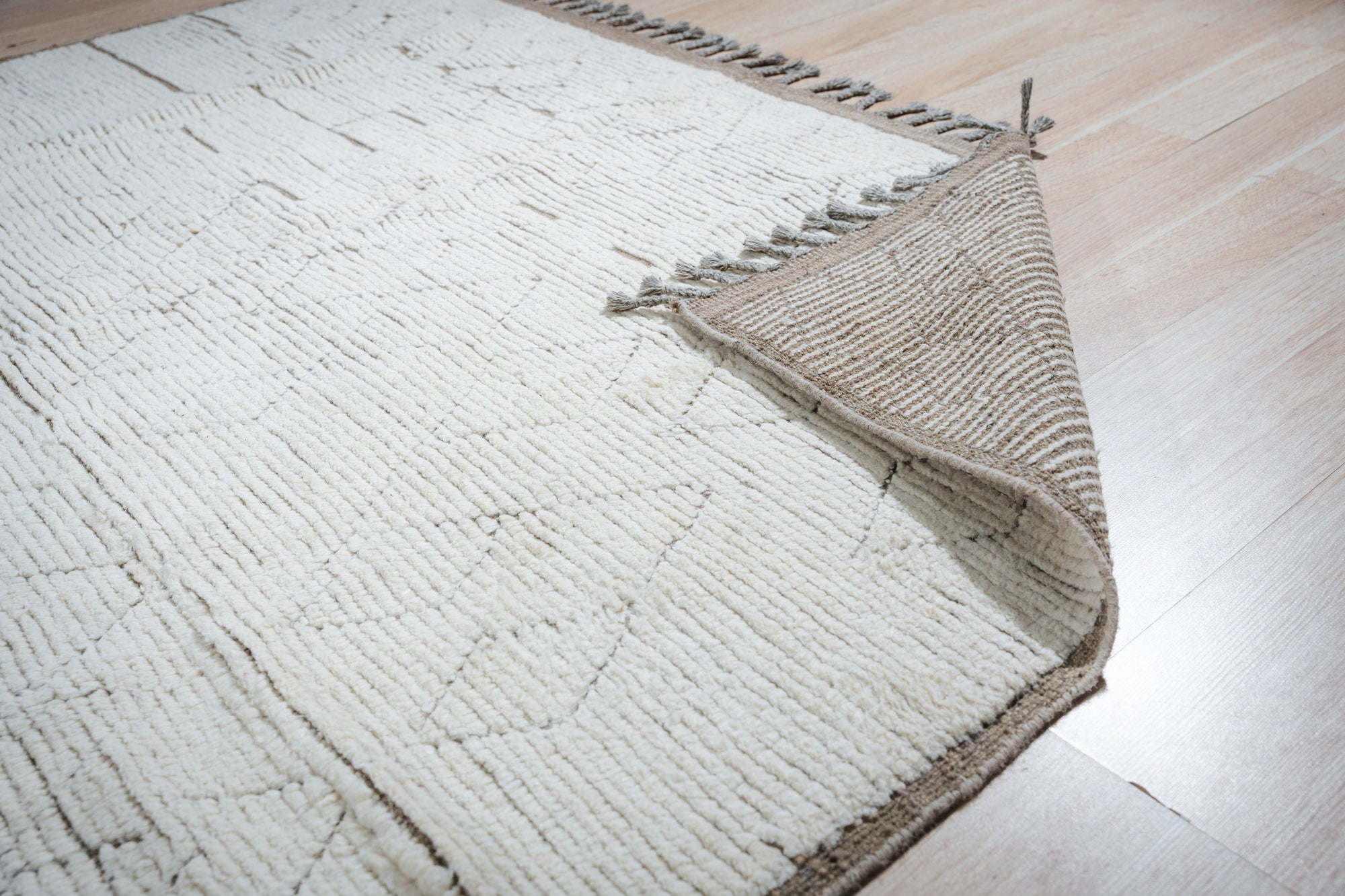 Marrakech Serenity Ivory Rug, a soft ivory rug with subtle geometric patterns, displayed in a bright, modern living room setting, offering a serene and inviting atmosphere.