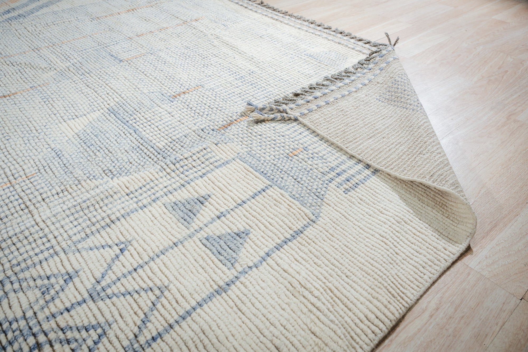 Aurora Multicolor Marrakech Rug, vibrant patterns dance across a low-pile wool rug in a bright, airy living room setting. Geometric motifs in a kaleidoscope of colors bring bohemian flair to the space.