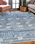 Elegant Marrakech Blue Hand-Knotted Wool Rug, vibrant blues and creams dance across a hand-knotted wool rug, illuminating a sunlit living room with intricate Moroccan-inspired motifs.