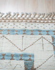 Timeless Marrakech Ivory Hand-Knotted Wool Rug, a warm ivory wool rug with a traditional Moroccan design, shown in a brightly lit living space.