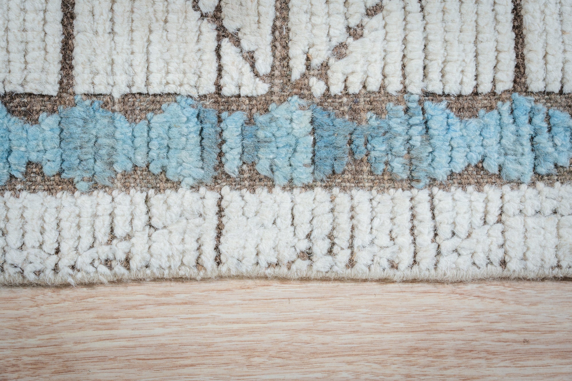 Timeless Marrakech Ivory Hand-Knotted Wool Rug displayed in a living room setting, its plush ivory wool adding warmth and texture to the space.