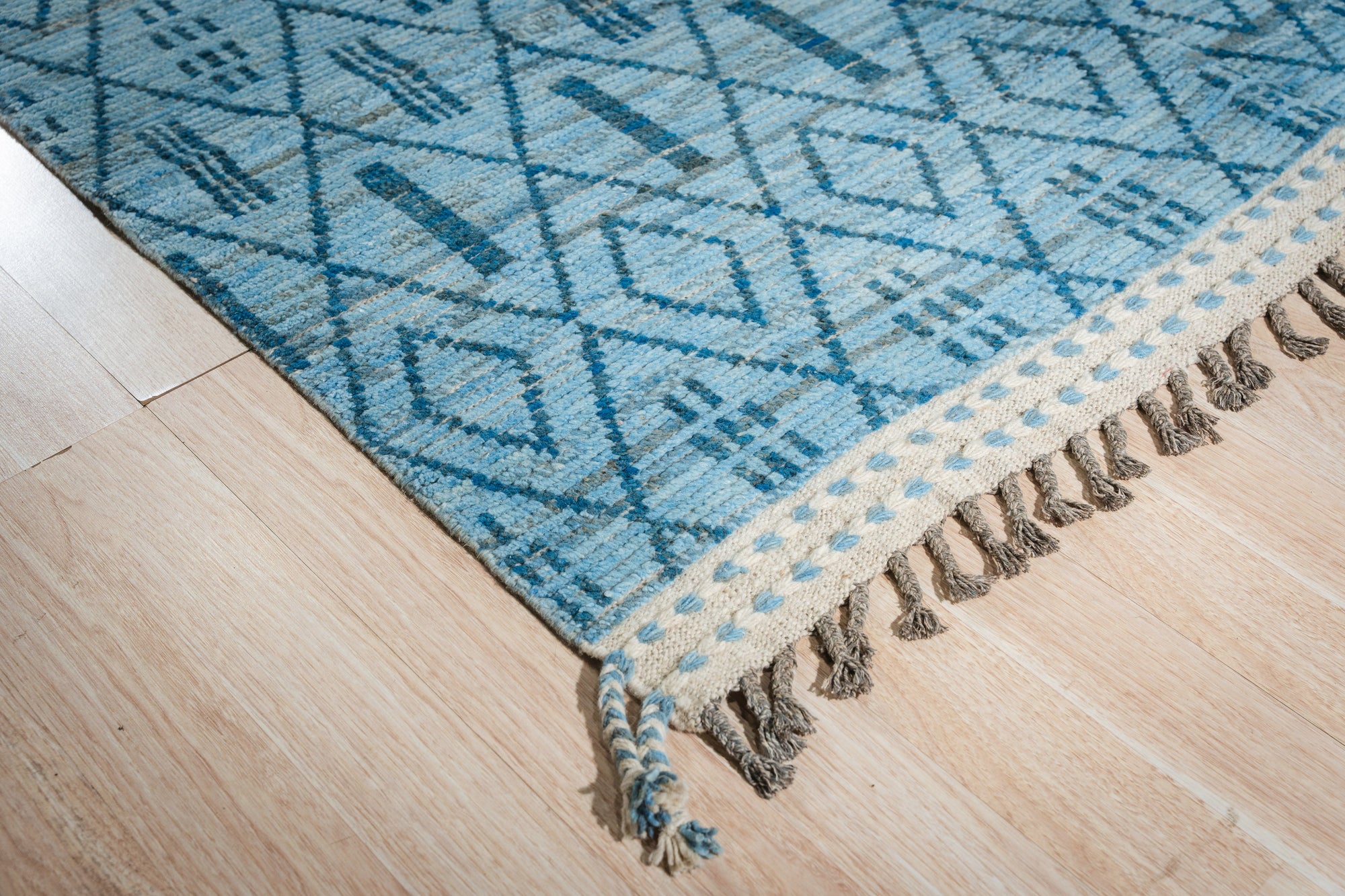 Stylish Marrakech Blue Hand-Knotted Wool Rug, showcasing intricate geometric patterns in shades of blue and cream, adding a vibrant global touch to a modern living space.