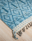 Stylish Marrakech Blue Hand-Knotted Wool Rug, showcasing intricate geometric patterns in shades of blue and cream, adding a vibrant global touch to a modern living space.