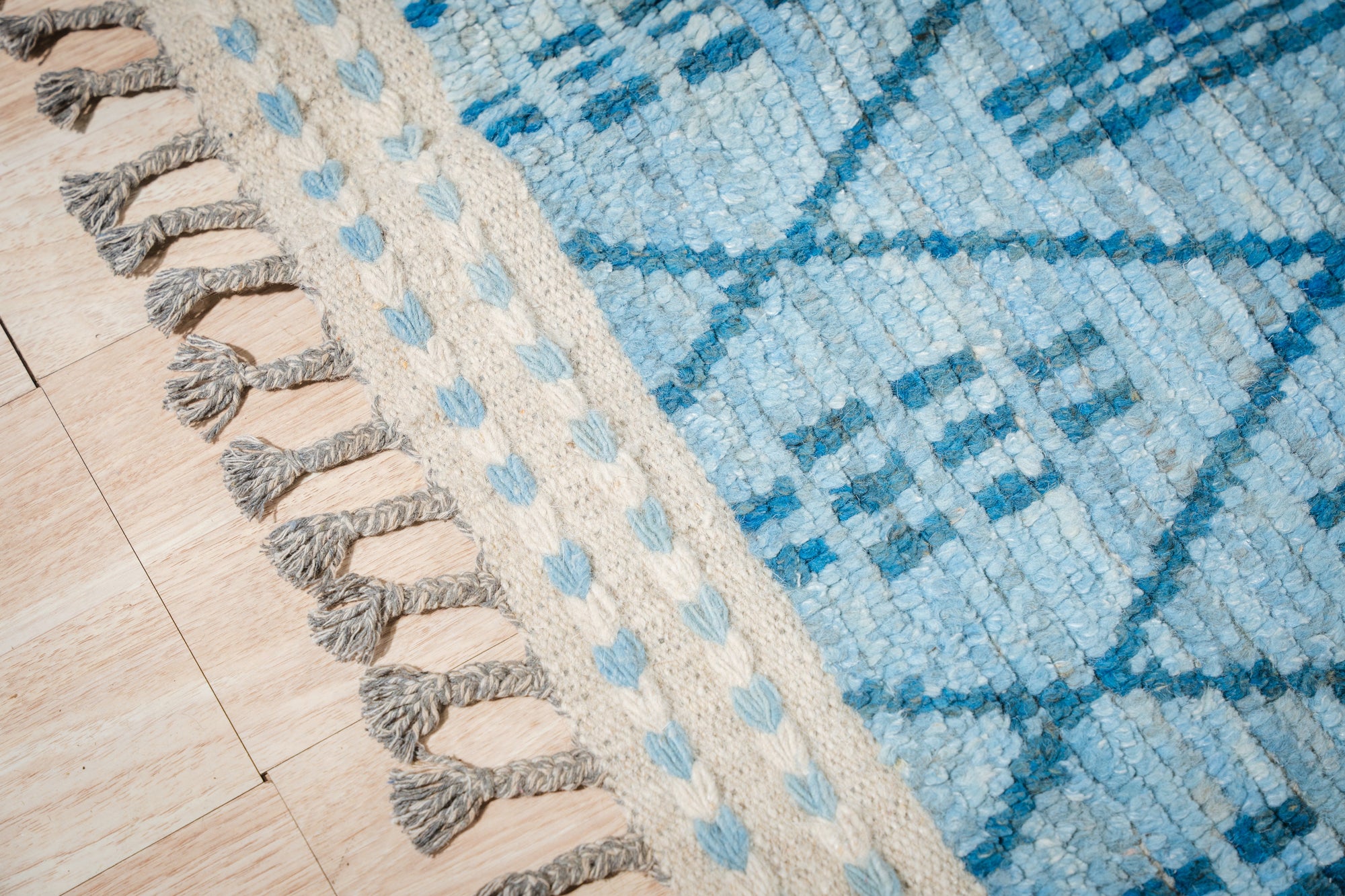 Stylish Marrakech Blue Hand-Knotted Wool Rug displayed in a modern living room, showcasing intricate geometric patterns and a vibrant blue hue complementing the neutral décor.
