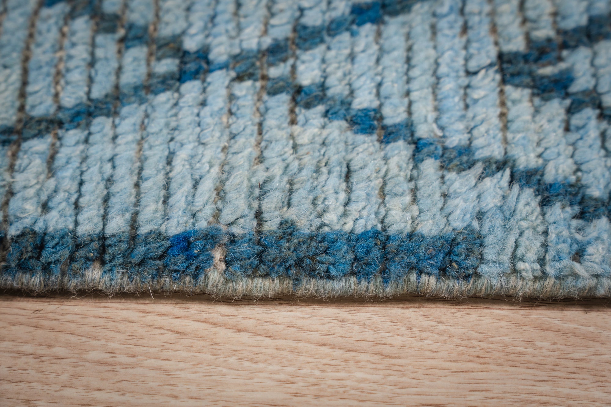 Stylish Marrakech Blue Hand-Knotted Wool Rug, its intricate geometric patterns in shades of blue and cream lending an authentic Moroccan vibe to a modern living space.