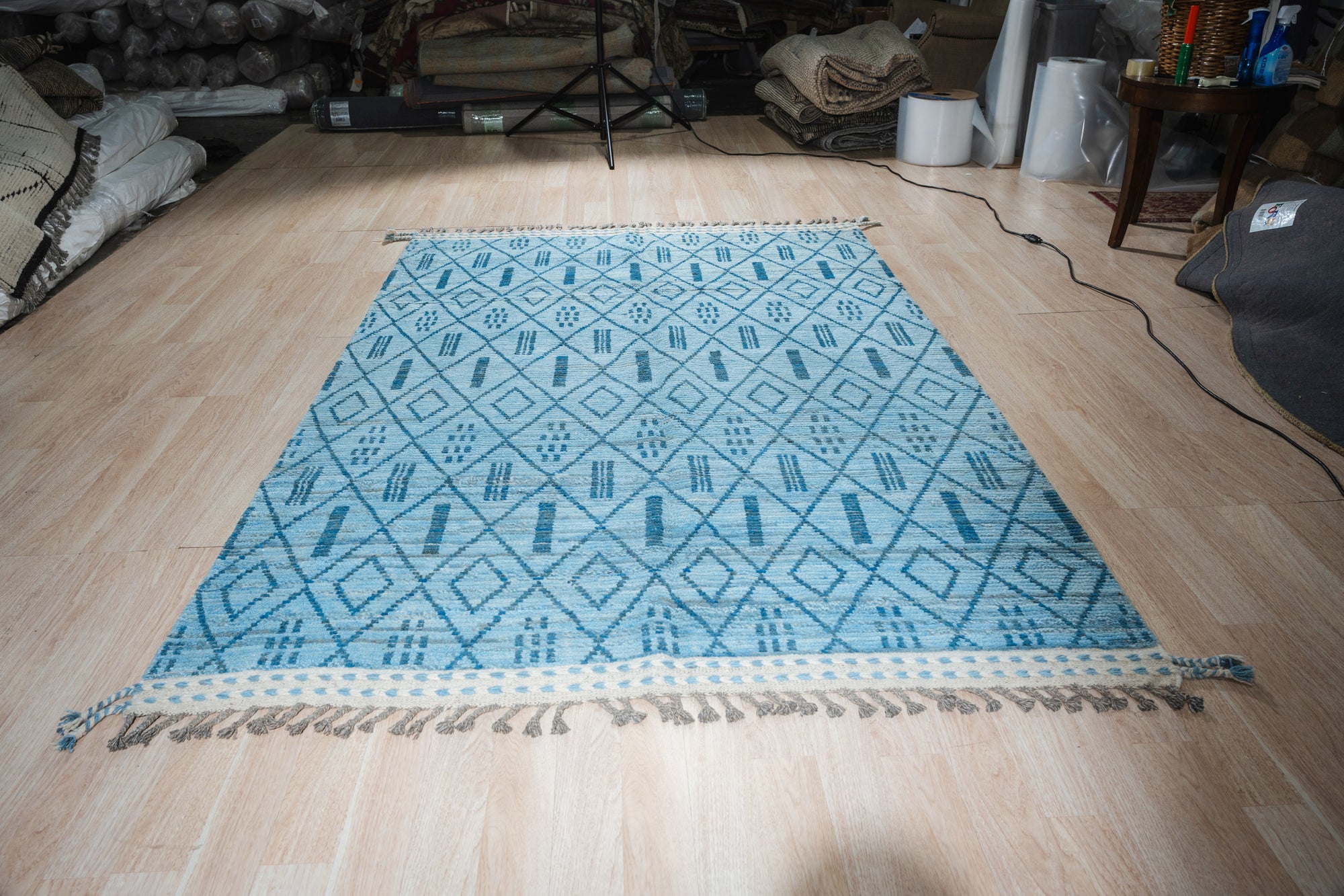 Stylish Marrakech Blue Hand-Knotted Wool Rug, vibrant blues and intricate geometric patterns unfold across this hand-knotted wool rug, showcased within a warmly lit interior space, inviting comfort and timeless style.