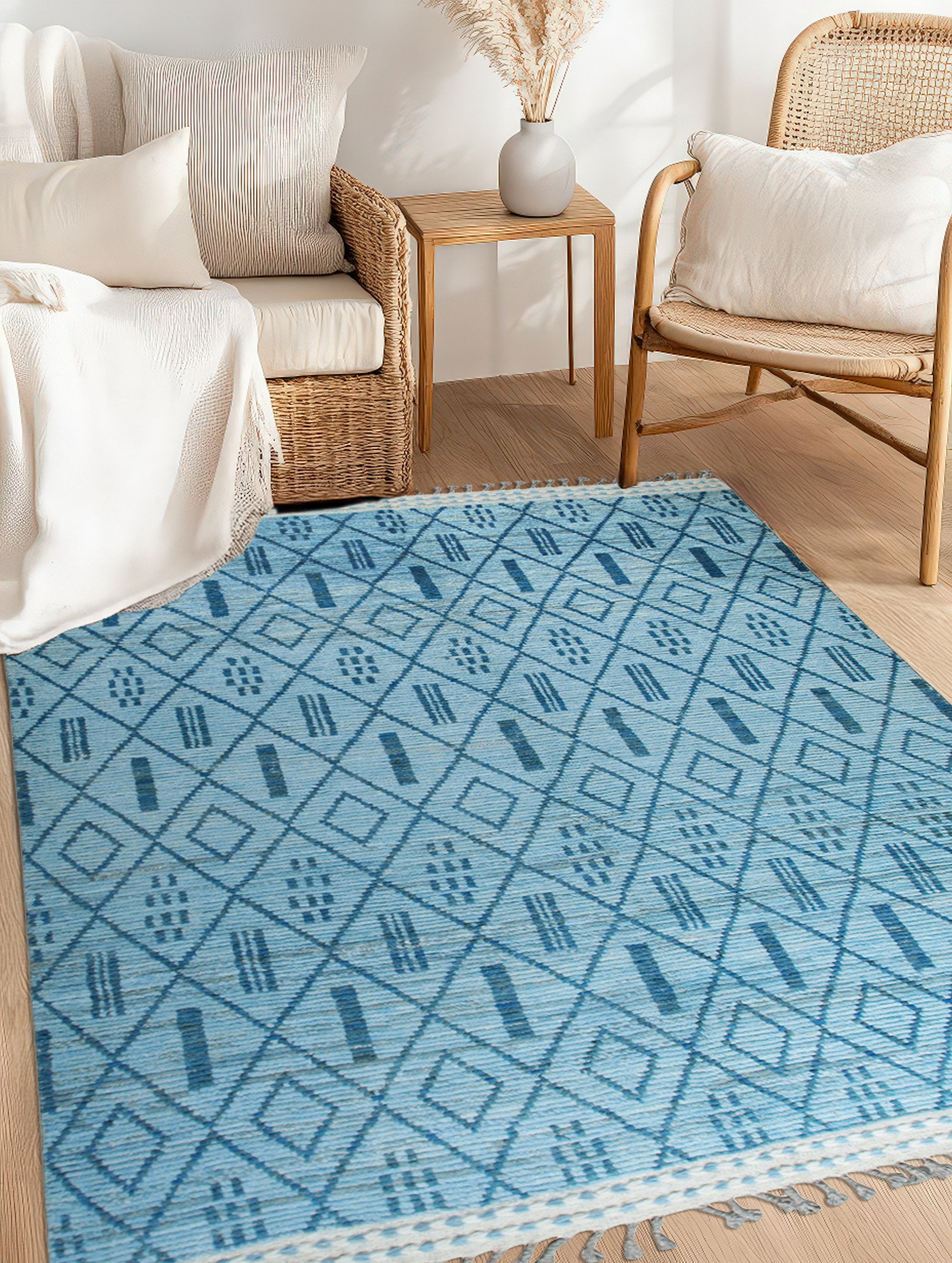 Stylish Marrakech Blue Hand-Knotted Wool Rug, showcasing an intricate geometric pattern in shades of blue and cream, laid out on a light hardwood floor, enhancing a living space.