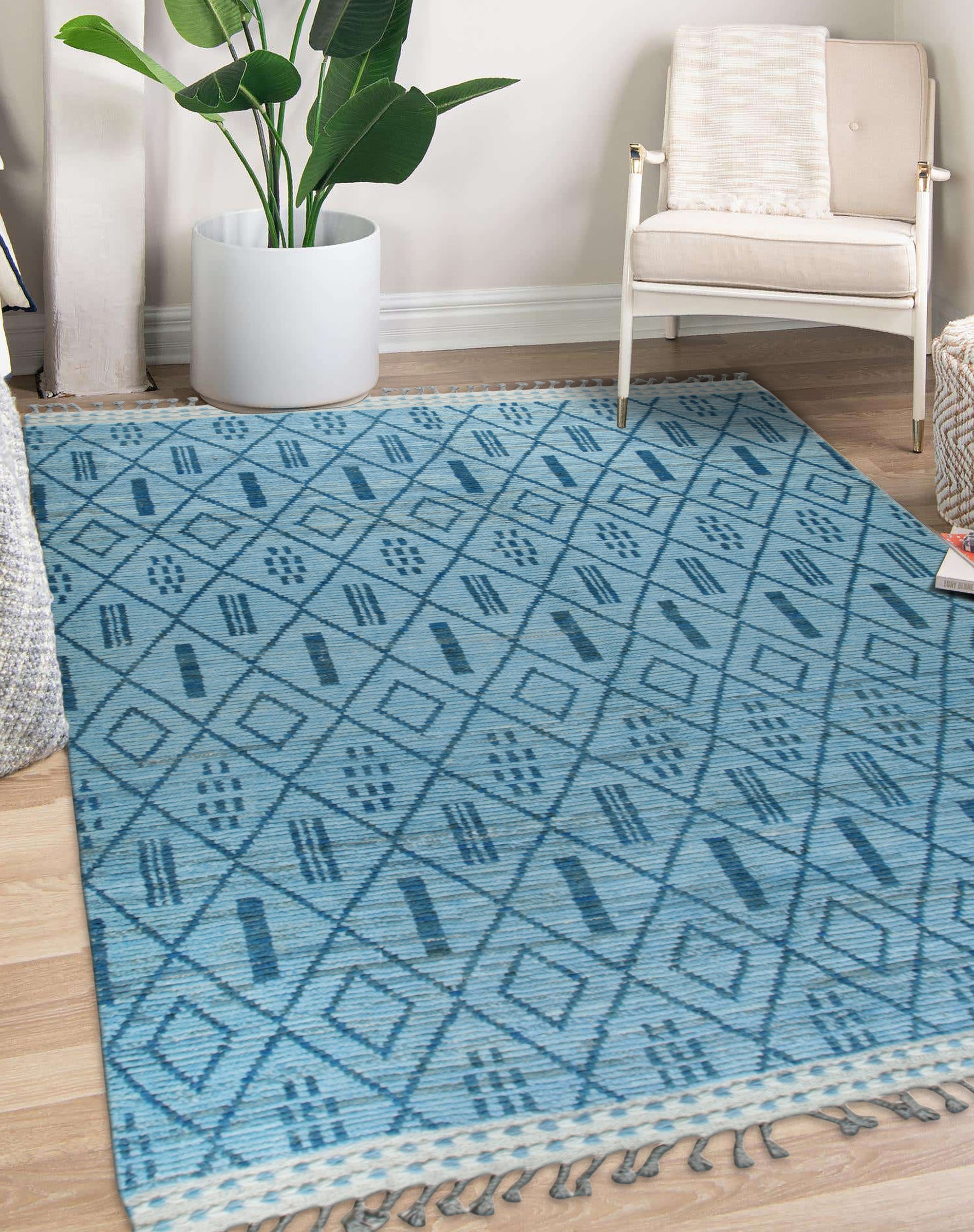 Stylish Marrakech Blue Hand-Knotted Wool Rug, showcasing intricate geometric patterns in shades of blue and ivory, complementing a modern living room with light wood floors and neutral furniture.