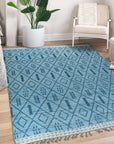Stylish Marrakech Blue Hand-Knotted Wool Rug, showcasing intricate geometric patterns in shades of blue and ivory, complementing a modern living room with light wood floors and neutral furniture.