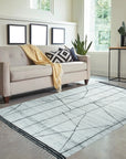 Refined Marrakech Ivory Hand-Knotted Wool Rug, boasting subtle geometric patterns woven in creamy ivory wool, displayed in a bright, modern living room setting.