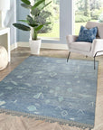 Charming Marrakech Blue Hand-Knotted Wool Rug, a vibrant blue and white wool rug with a geometric Moroccan-inspired design, partially visible layered under a modern coffee table in a bright living space.