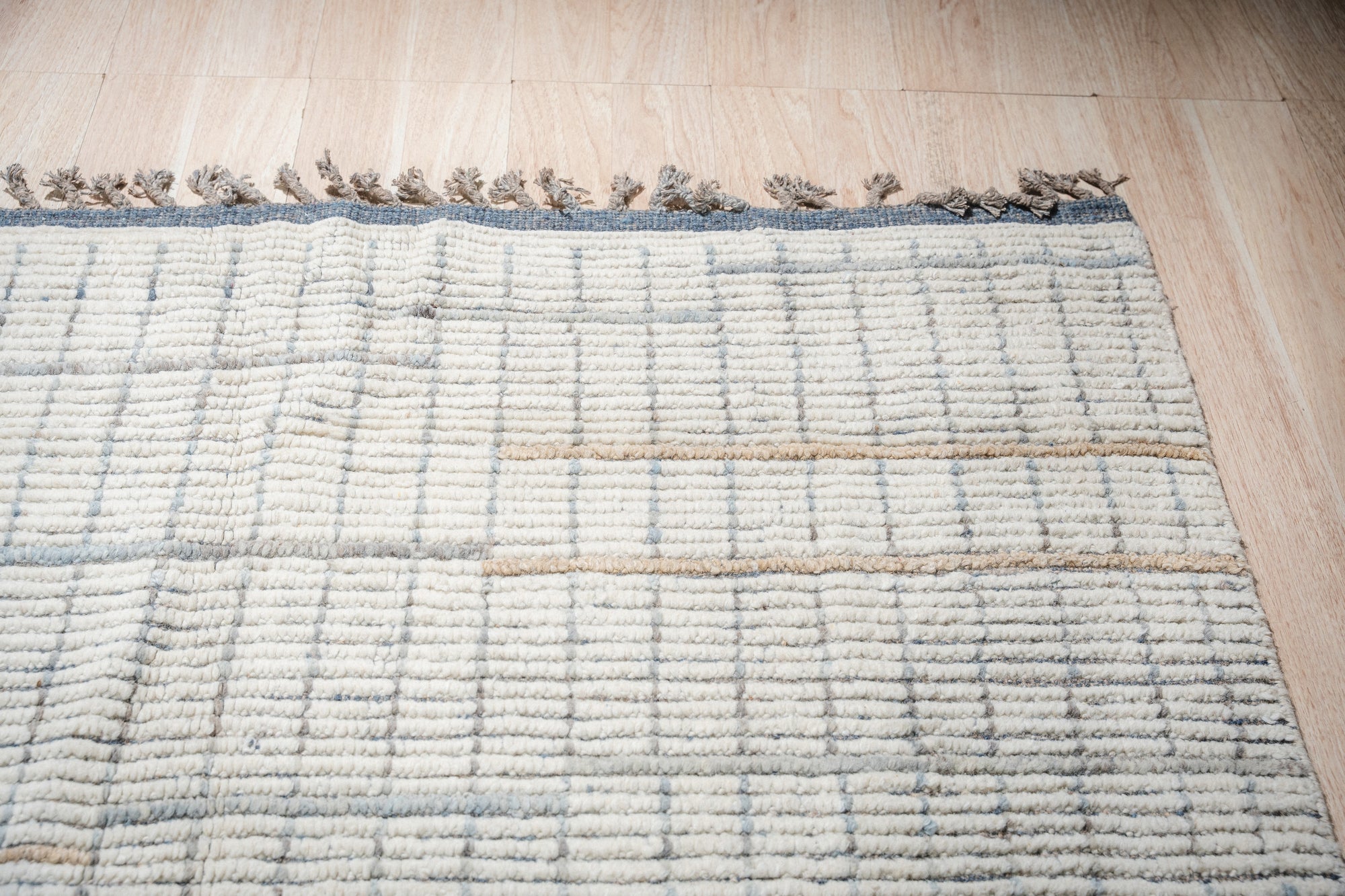 Ornate Marrakech Ivory Hand-Knotted Wool Rug, showcasing intricate traditional patterns in warm ivory tones, lending a sophisticated touch to a well-lit living space.