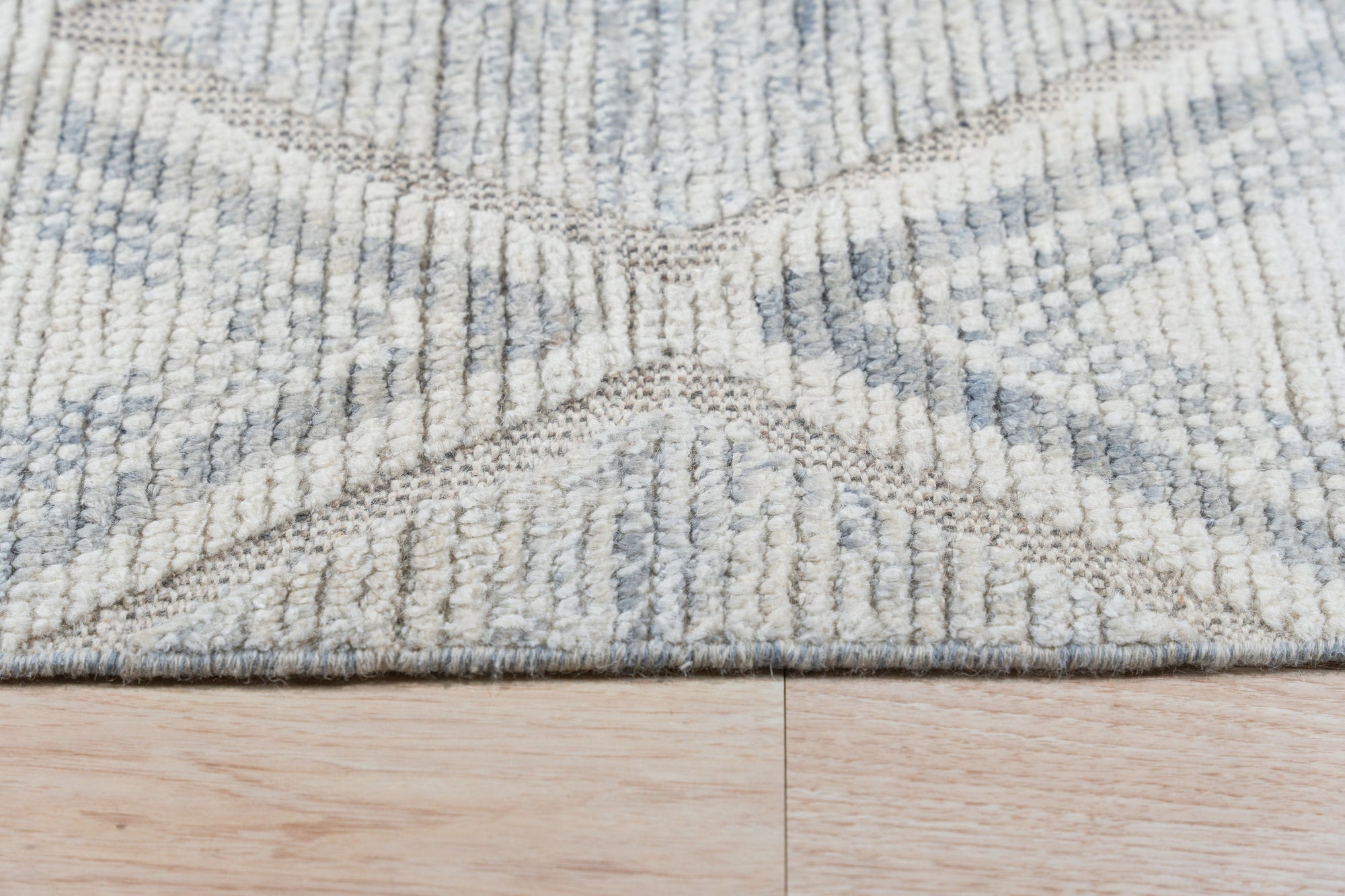 Elegant Marrakech Beige Hand-Knotted Wool Rug, showcasing its intricate geometric design in soft beige hues, lies serenely in a bright, modern living space.