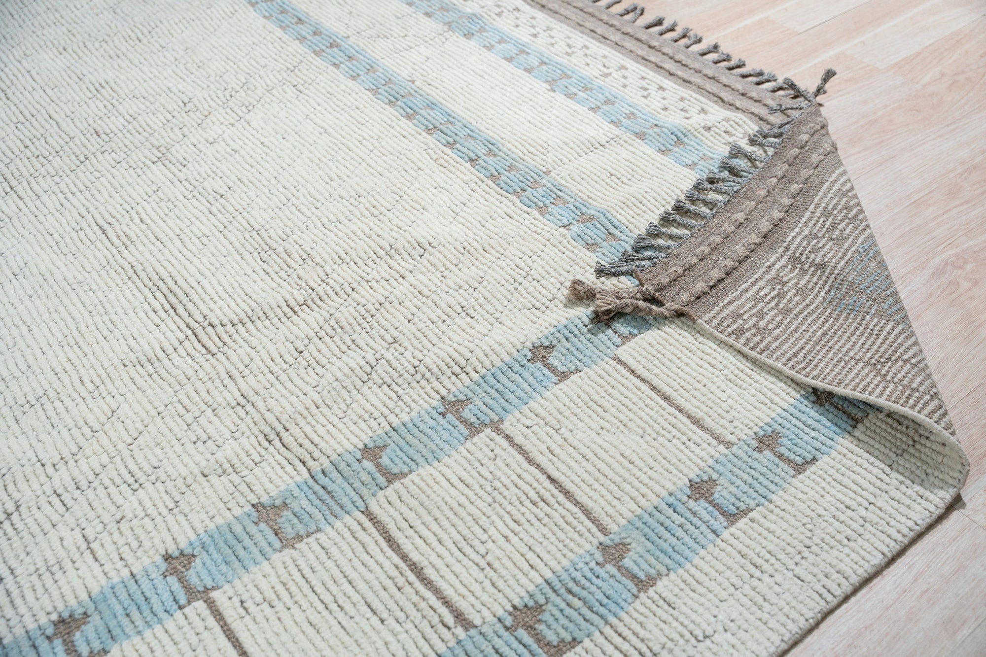 Timeless Marrakech Beige Hand-Knotted Wool Rug, blending seamlessly into a light-filled living room, its intricate geometric patterns and warm beige tones enhancing the sophisticated, modern setting.