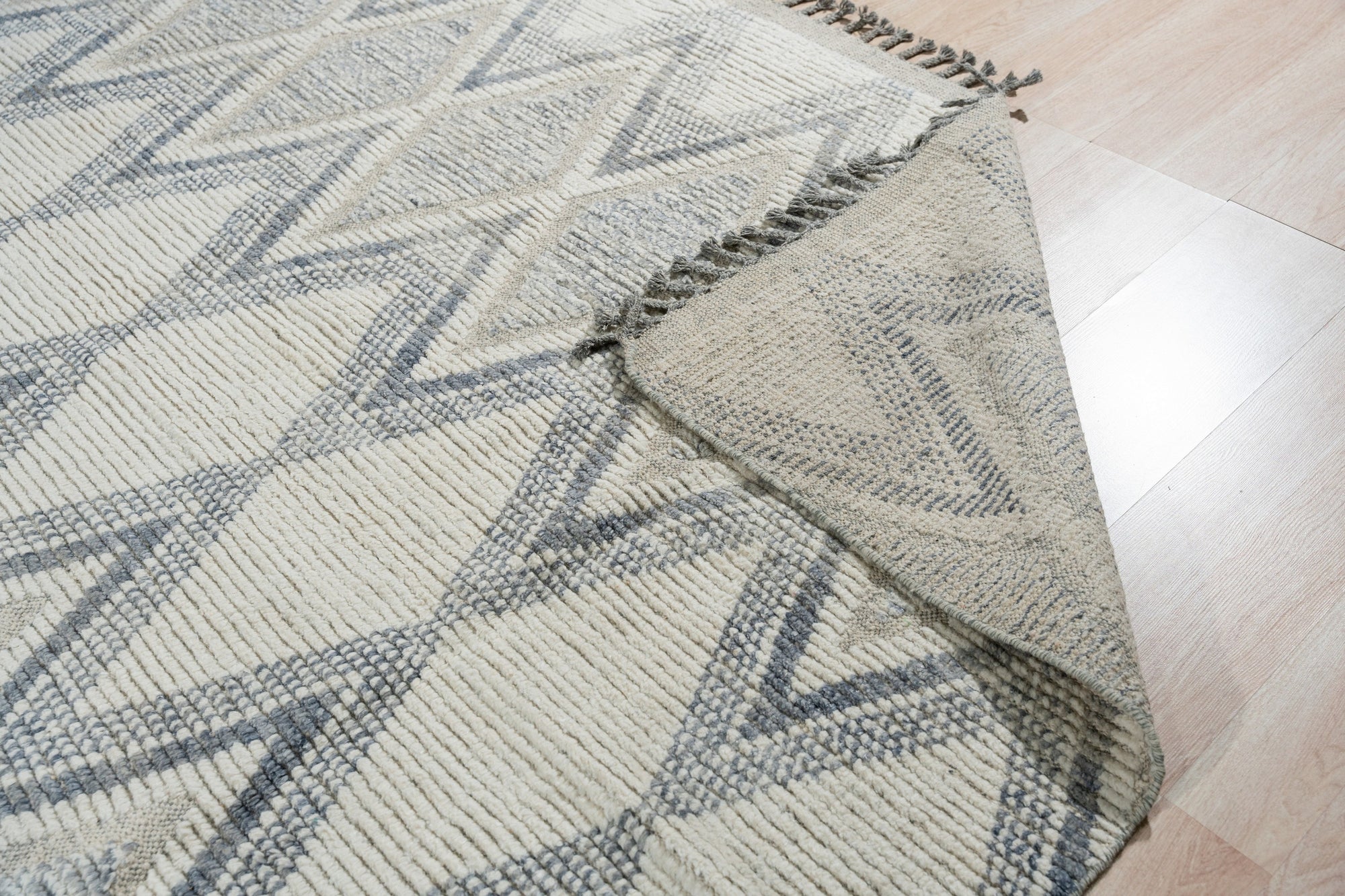 Sophisticated Marrakech Beige Hand-Knotted Wool Rug, showcasing intricate geometric patterns in soft beige tones, enriching a warmly lit living room setting.