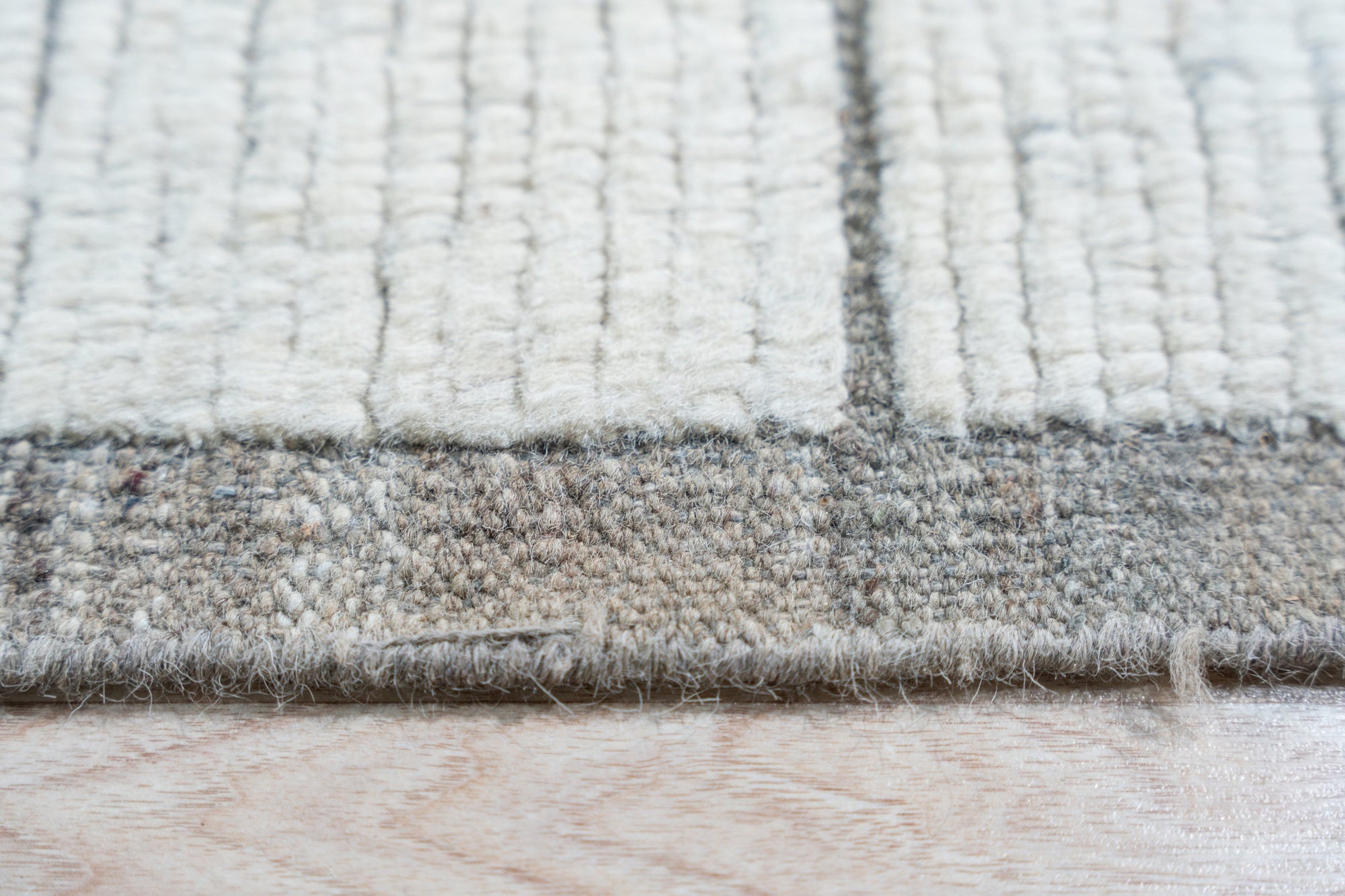 Refined Marrakech Beige Hand-Knotted Wool Rug, showcasing intricate geometric patterns in warm beige tones, softly textured and laid in a bright, modern living room setting.