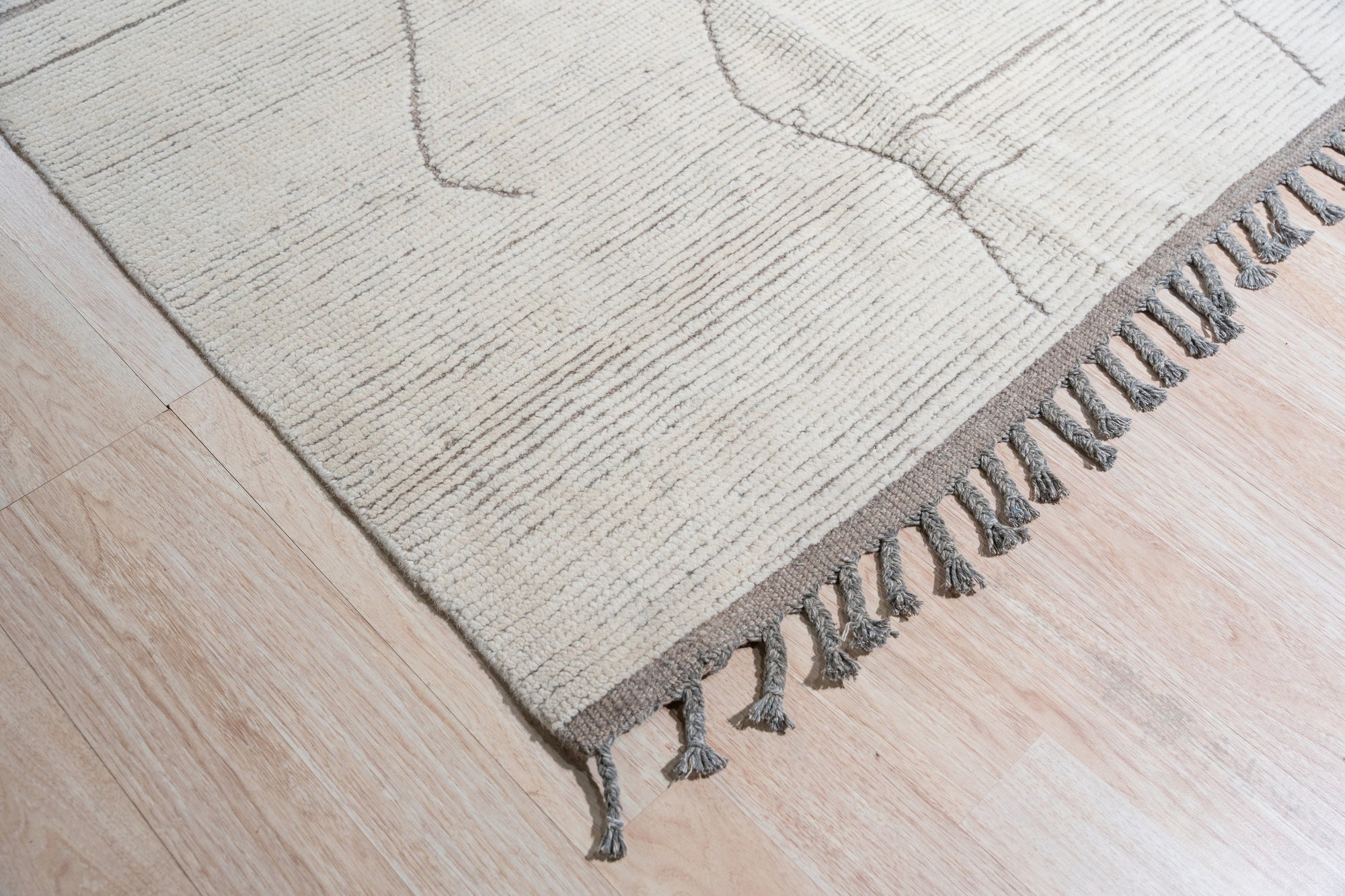 Vintage Marrakech Beige Hand-Knotted Wool Rug, its warm beige tones and intricate hand-knotted texture softening a modern living space, with sunlight highlighting the wool's natural luster.
