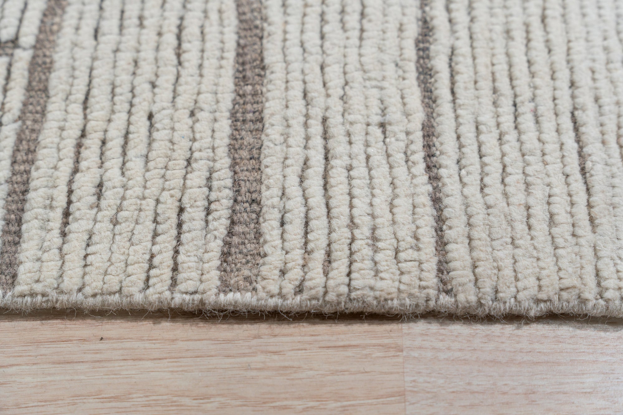 Vintage Marrakech Beige Hand-Knotted Wool Rug, its intricate geometric patterns and warm beige hues softening a bright, modern living room with natural light.