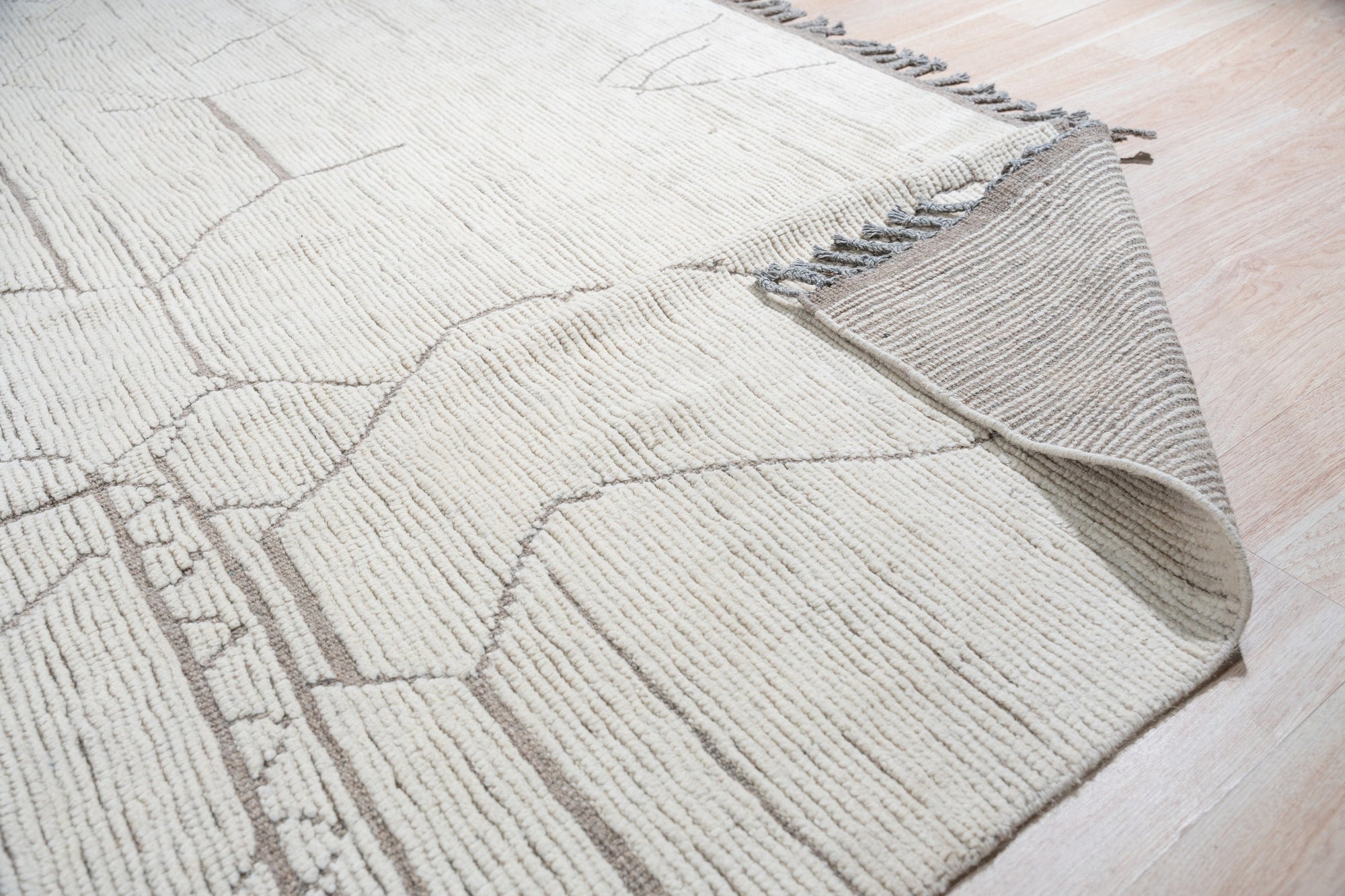 Vintage Marrakech Beige Hand-Knotted Wool Rug, its subtle geometric pattern in creamy beige softening a modern living space, hints of warm terracotta and faded charcoal adding depth to its hand-knotted texture.