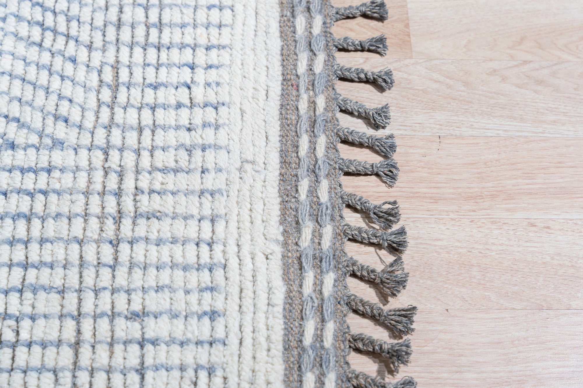 Subtle Marrakech Ivory Hand-Knotted Wool Rug, showcasing its textural ivory wool field with a subtle, geometric Moroccan-inspired design, complements a light-filled room with neutral furniture and warm wood accents.