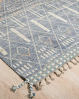 Timeless Marrakech Blue Hand-Knotted Wool Rug, showcased on a light wood floor, reveals intricate geometric patterns in shades of blue and cream, a testament to its hand-knotted wool construction.