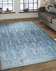 Graceful Marrakech Blue Hand-Knotted Wool Rug, showcasing intricate geometric patterns and soft blue hues in a styled living room setting.