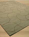 Sumptuous Maya Blue Hand Tufted Wool Rug, a rich blue wool rug with a subtle, textured design, rests on a light hardwood floor, showcasing its plush pile and vibrant color.