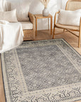Rhea Elena Purple Hand Knotted Wool Rug, displaying a detailed pattern with varying shades of purple and subtle complementary colors, seen in a bright, naturally lit interior setting, highlighting its texture and luxurious feel.