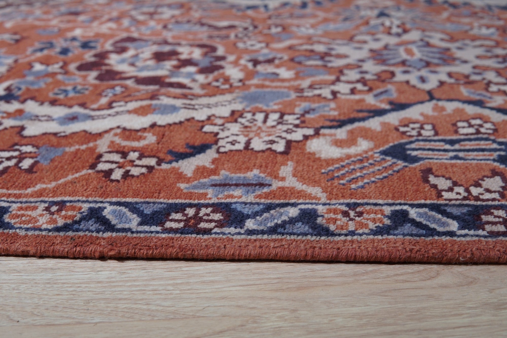 Lush Rustic Rust Hand Knotted Wool Rug, rich rust hues interwoven in a hand-knotted construction, displayed in a room setting.