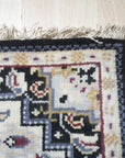 Luxurious Traditional Beige Hand Knotted Wool Rug, showcasing intricate floral and geometric motifs in soft beige tones; detail highlights the wool's hand-knotted construction.