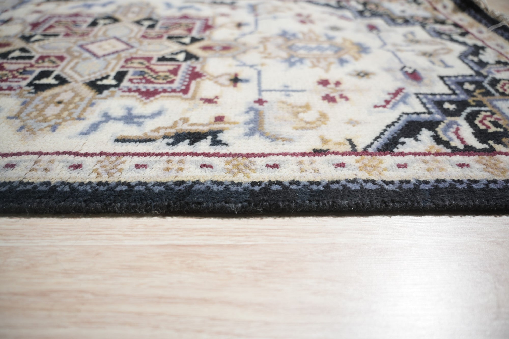Luxurious Traditional Beige Hand Knotted Wool Rug, displaying intricate floral patterns in beige and muted greens on a cream field, presented in a well-lit room setting.